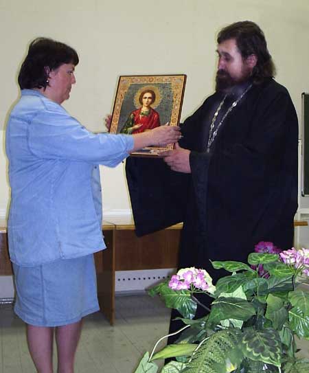 Протоиерей Олег Кропочев передает икону великомученика Пантелеимона главному врачу ульяновской областной детской многопрофильной больницы.